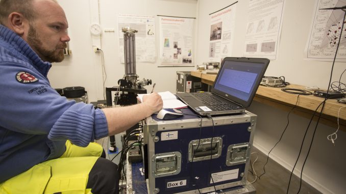 Jyri_Näränen_mittaamassa_kuva_Maanmittauslaitos Tutkimuspäällikkö Jyri Näränen tekee painovoimamittauksia absoluuttigravimetrillä. Kuva: Maanmittauslaitos.