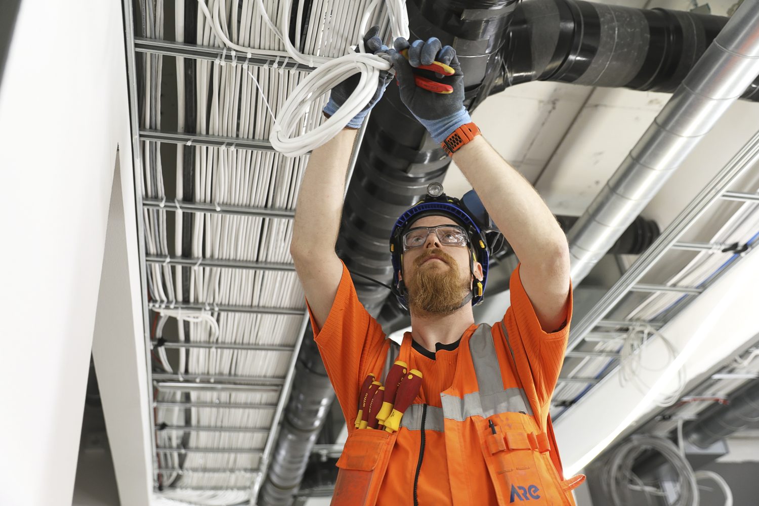 Asentaja_Toni_Tapani_Ylen_toimistossa_valaistuskaapeloinnit-maria-heinola